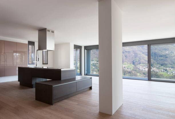 Vivienda con reforma integral terminada en Mallorca: cocina abierta con isla central y salón con grandes ventanales y vistas al valle
